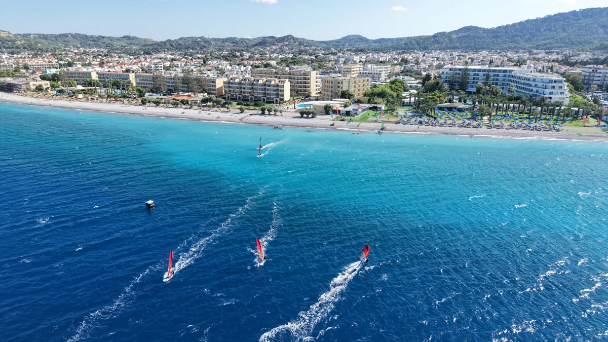 The turquoise bay of Trianda with windsurfers and the Rhodes coastline