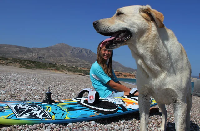 Family beach memories on Karpathos, with a dog beside a windsurf board