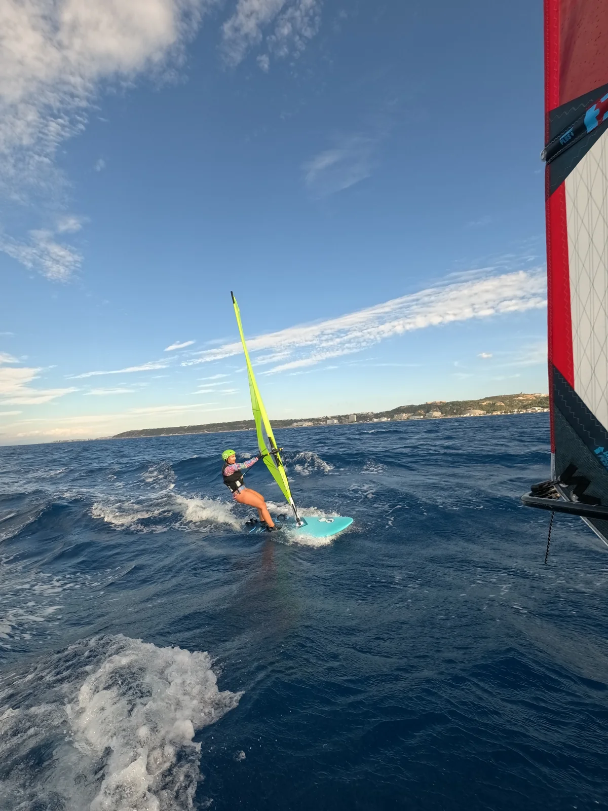 Windsurfer practising alongside the coach